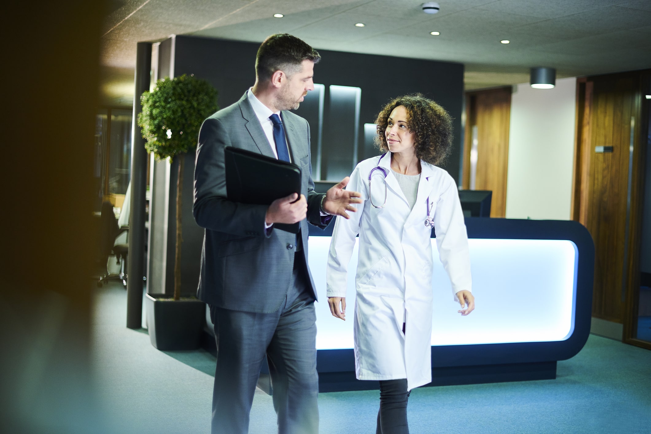 consultant and doctor walk and discuss in hospital