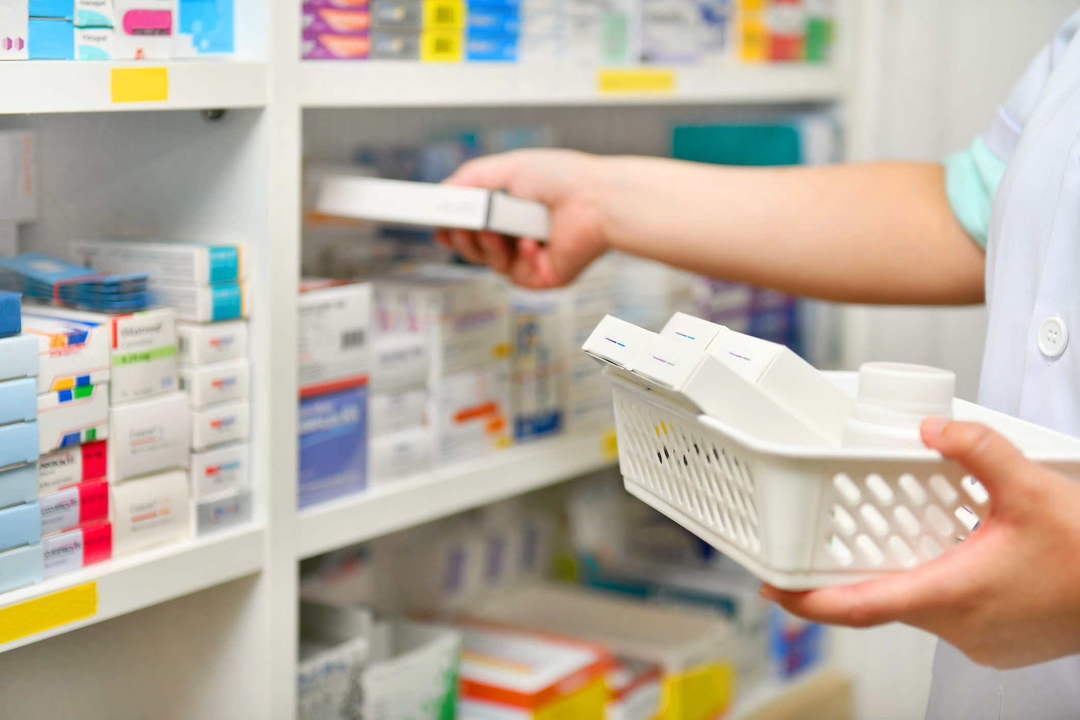 pharmacist putting medication away on shelf